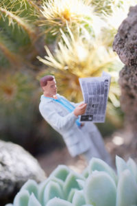 Icon image of information, diorama, miniature, man reading newspaper, spiky environment, portrait format Icon image of information, diorama, miniature, man reading newspaper, spiky environment, portrait format
